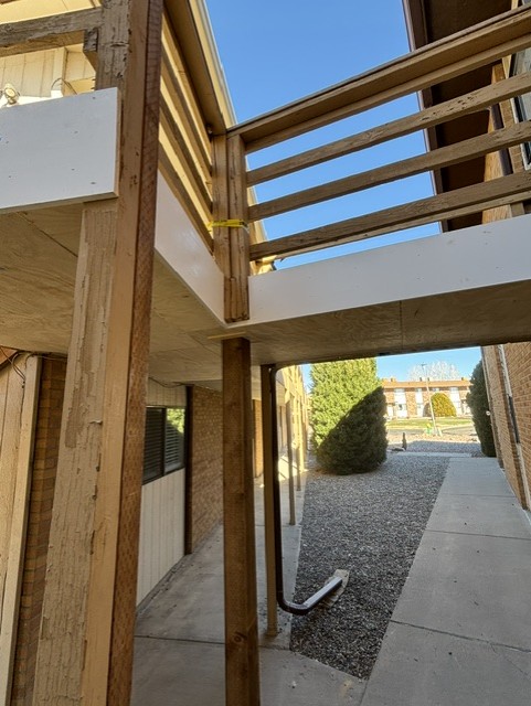 Rebuilt exterior staircase and balcony framing with new structural posts and beams